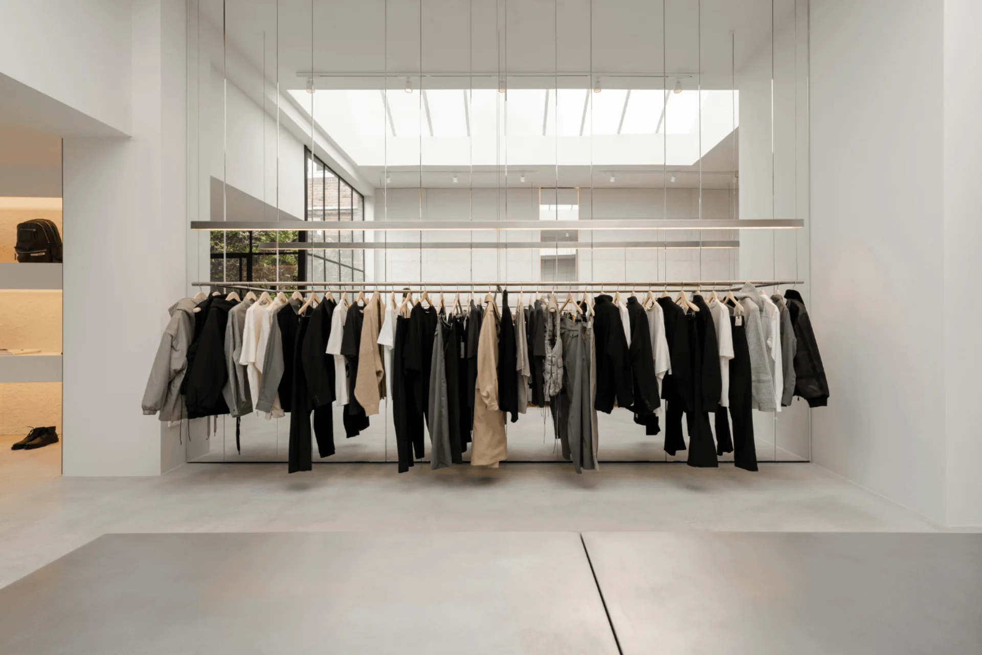 Kledingrek onder dakraam met microcement afwerking in concept store Amsterdam