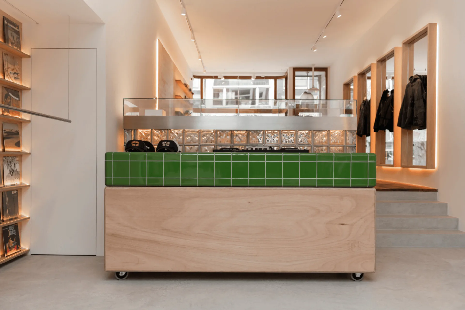 Toonbank met groene tegels en producten naast microcement vloer in concept store